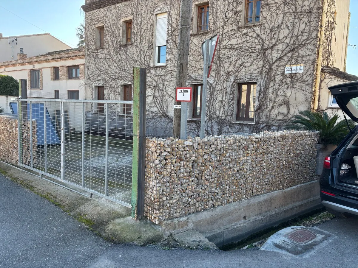 Fachada y muro de gaviones de la propiedad en invierno