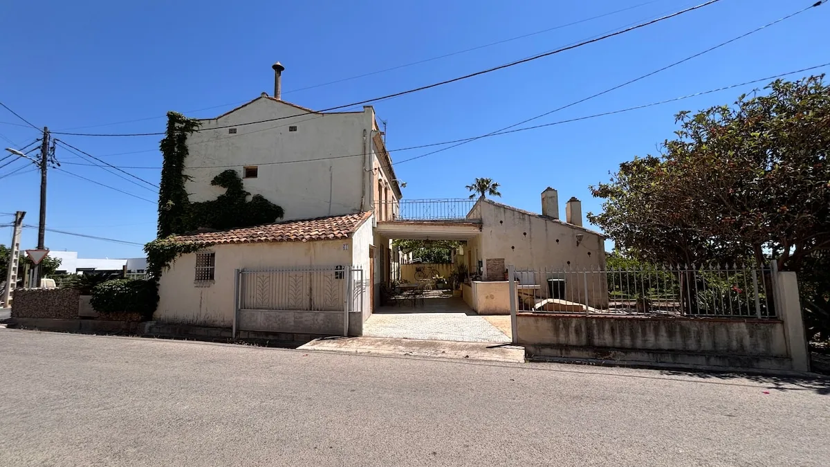 Vista lateral de la casa con el porche y la entrada de vehículos